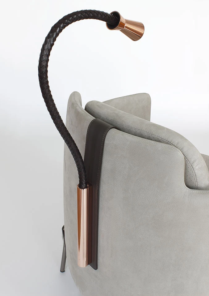 Klemmleuchte 'Battery' von Contardi an einem grauen Sessel befestigt