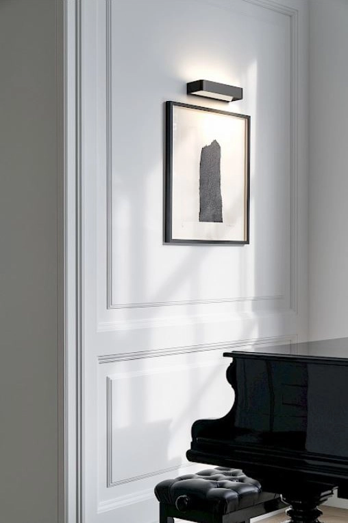 In einem Raum mit einem Klavier wird die an der Wand hängende Zeichnung von der Leuchte 'Frame' von Rotaliana ausgeleuchtet.